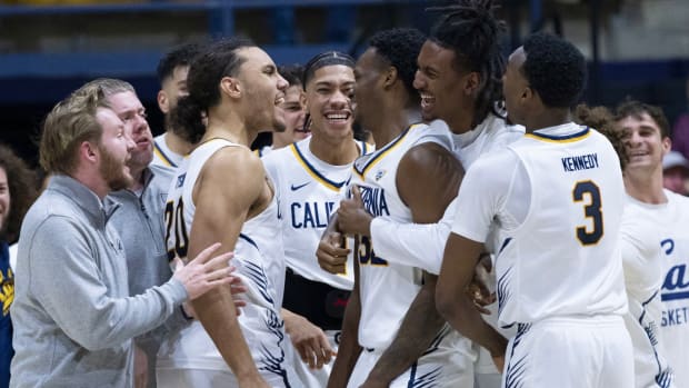Teammates mob Jalen Celestine, center, after his back-to-back steals and dunks